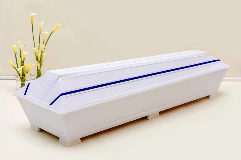 Valkoinen kangaspintainen hauta-arkku jonka kannessa on sininen raita
