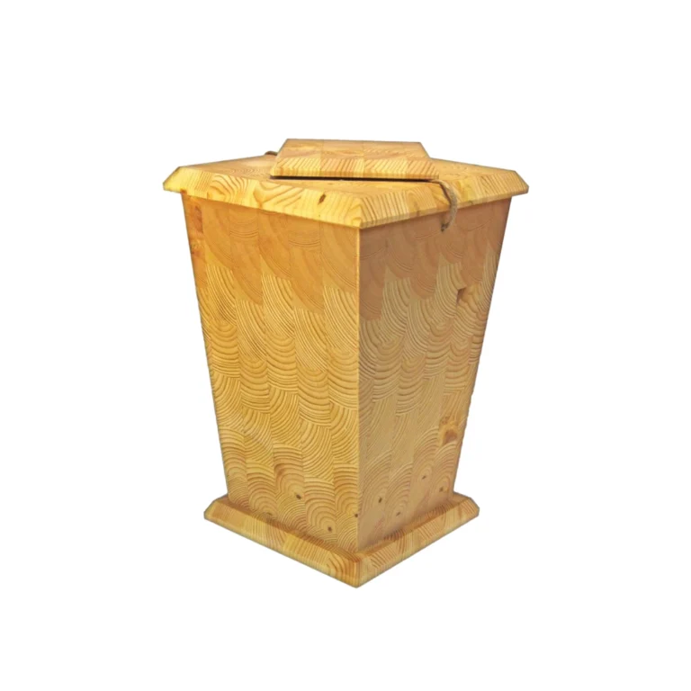 Jalopuinen uurna jossa näkyy puun oksien päät uurnan sivussa