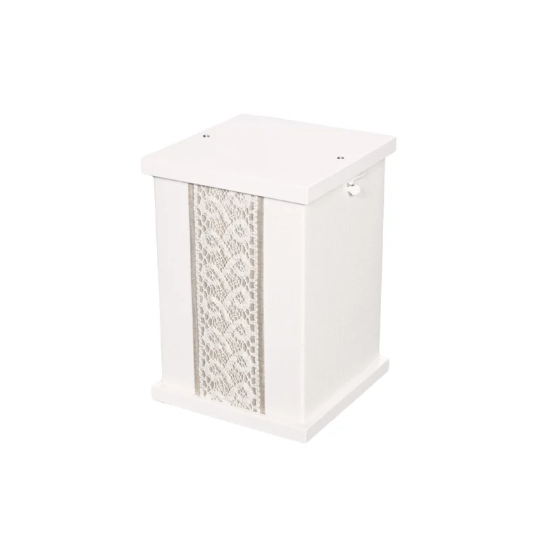 Valkoinen neliön mallinen uurna jossa on kankainen kuvioitu koristenauha sivussa